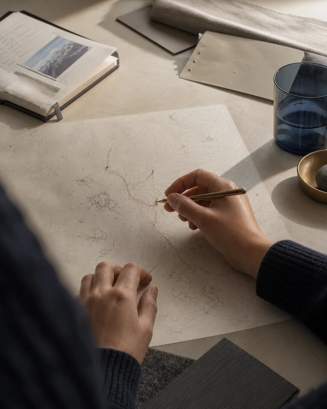 Manos de una diseñadora trazan una ruta entre muestras de materiales de ALISIO